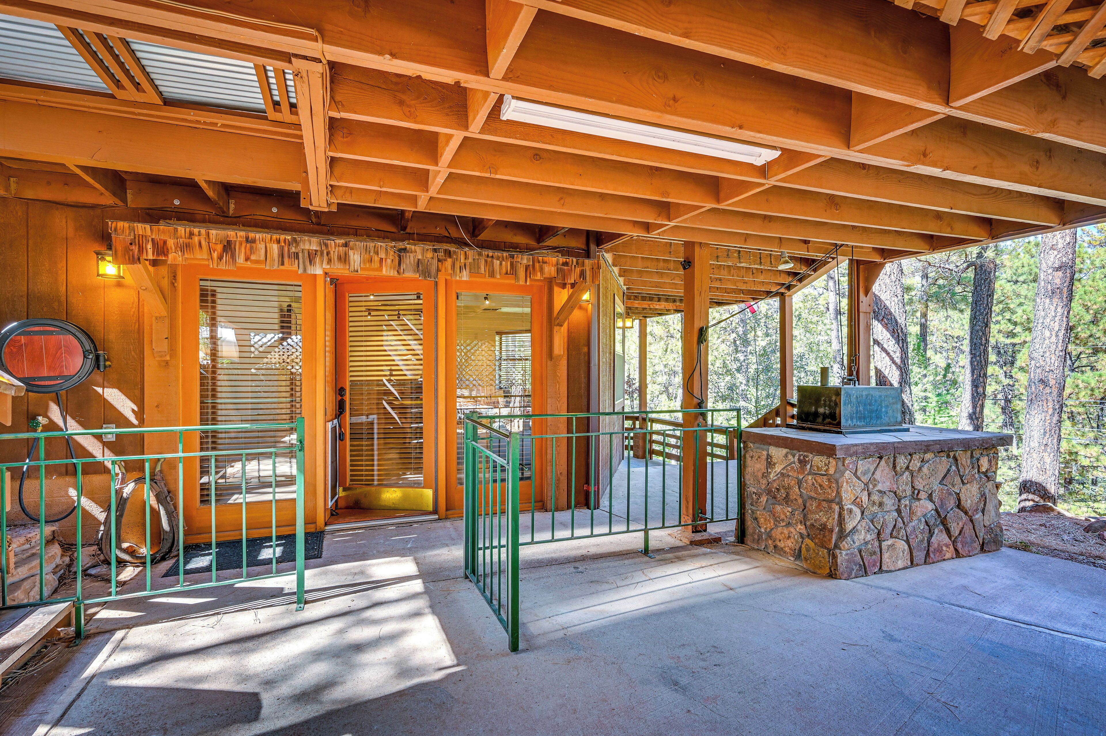 A covered wooden deck with a stone bench and a metal railing.