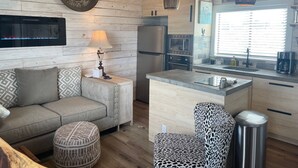 A modern kitchen with wooden cabinetry, a built-in microwave, and a stainless steel refrigerator. - AMAZING Cabin in the Heart of the Hill Country w/ breathtaking views,Pool & Spa! (Dripping Springs)