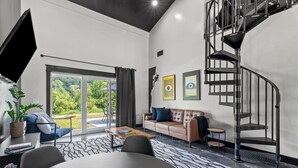 A modern living room with a sofa, coffee table, and a spiral staircase.