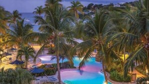 A resort with a swimming pool surrounded by palm trees and lounge chairs. - Gigi's Luxury Beach Hideaway- 3 BDRM- Cowpet Bay West- East End- Pool & Beach
 (St Thomas)