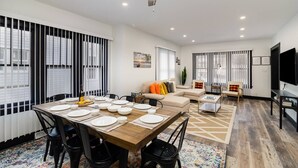 A modern living room with a dining area, a sofa set, a TV, and a ceiling fan. - Sand & Sun Getaway | Drive to Beach Game Room + 2 Living Areas |Game Room | Minutes to Beach (Michigan City)