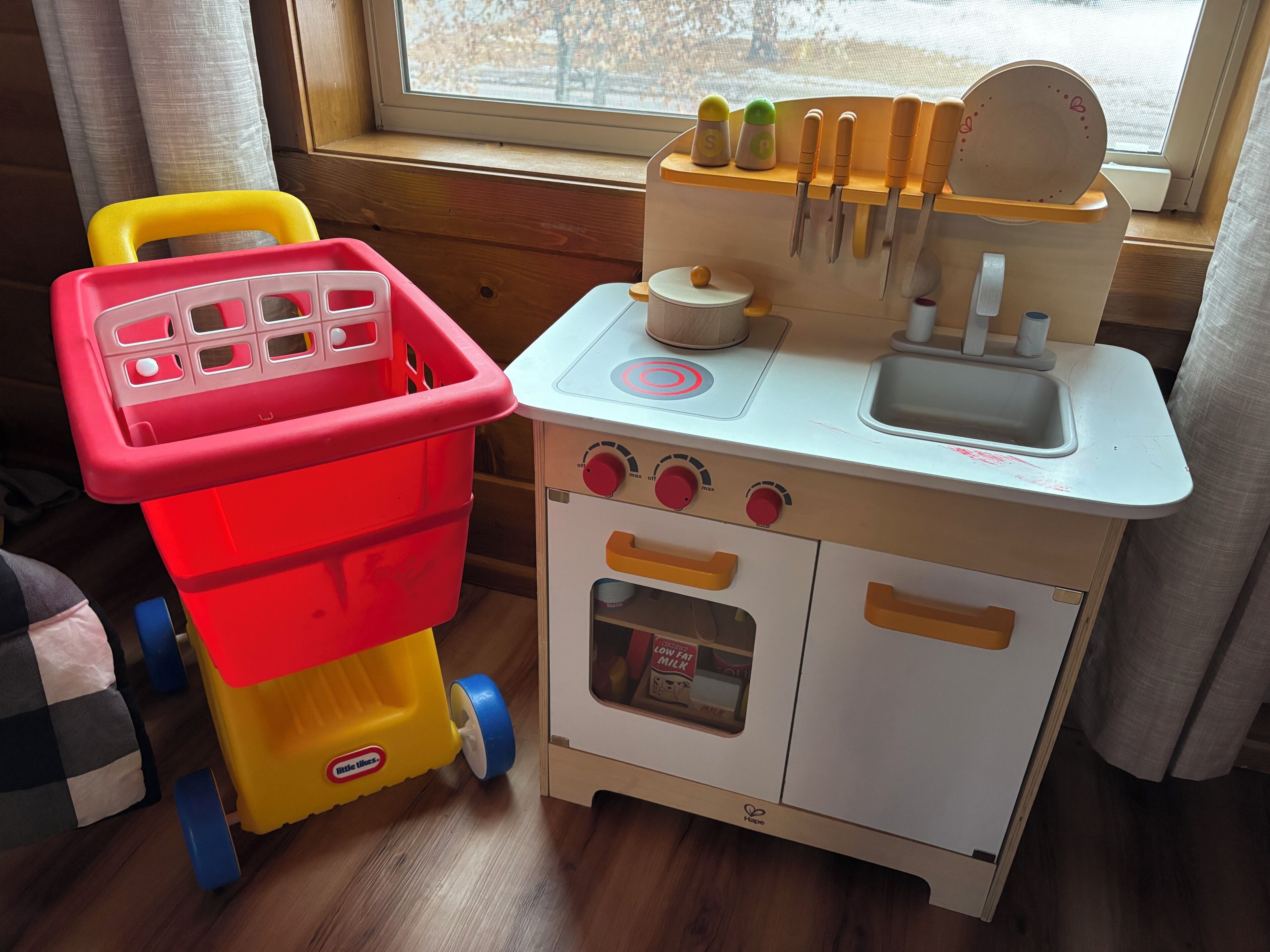 A toy kitchen with a sink, stove, and storage containers.