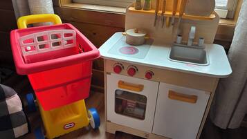 A toy kitchen with a sink, stove, and storage containers.