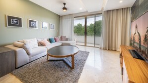 A modern living room with a sofa, coffee table, and artwork on the walls. - Luxury 2 Bedroom Condo at Haab (Playa del Carmen)