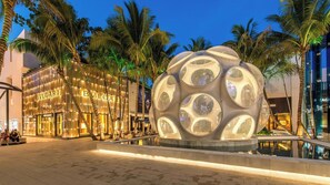 A modern building with a spherical structure in the center, surrounded by palm trees and a reflective pool. - Saltwater Pool, Firepit & Workspace I 7 min to Brickell (Miami)