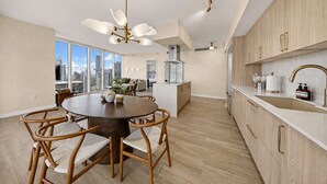 Una cucina moderna con mobili in legno, un tavolo rotondo con sedie e vista sulla città.