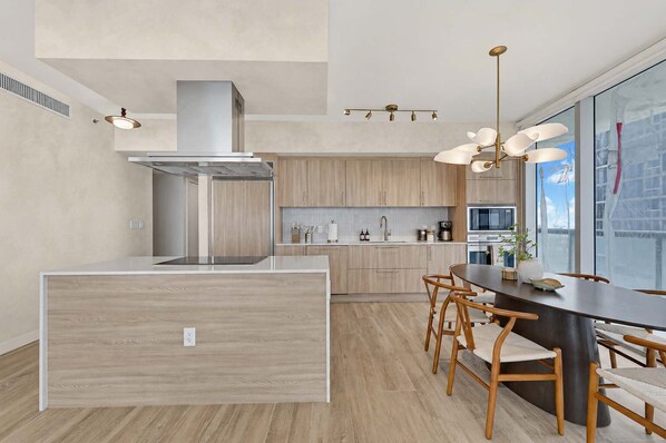 Une cuisine moderne dotée d’un îlot central, de meubles en bois et d’un coin repas avec des chaises.