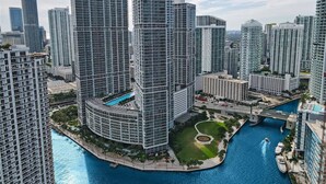 A high-rise urban area with modern architecture, a central circular building with a pool, and a waterway with boats. - Sunrise Water Views I Pool, Spa, Gym & Free Parking (Miami)