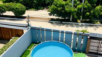 Una piscina en la azotea con vista al océano y la vegetación.