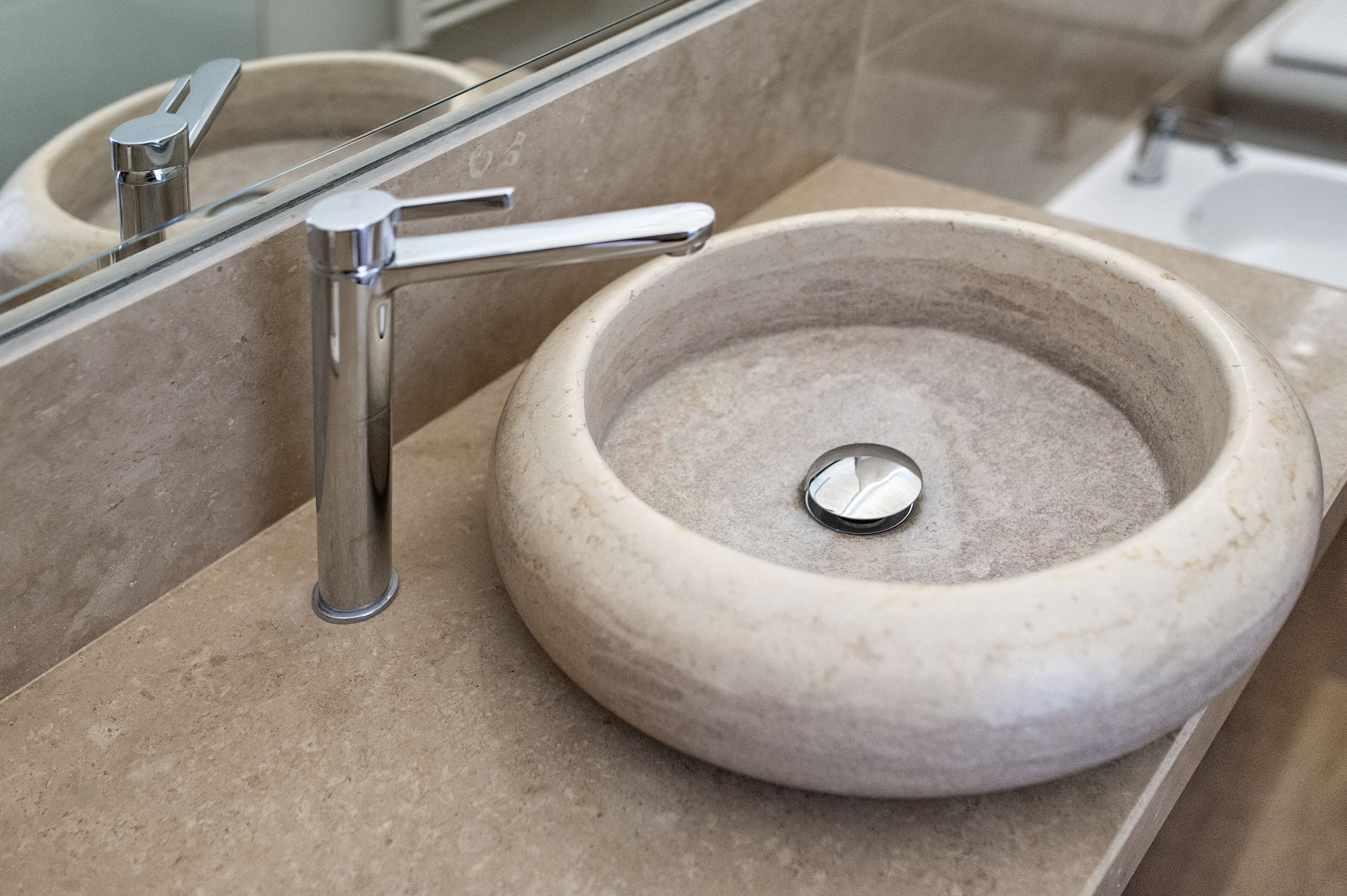 A bathroom with a modern sink, a chrome faucet, and a glass shower enclosure.