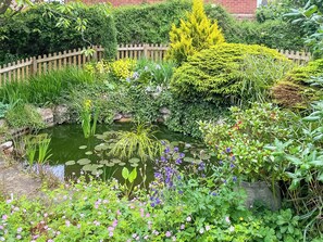 A garden with a pond, various plants, and a wooden fence. - 3 bedroom accommodation in Louth (Louth)