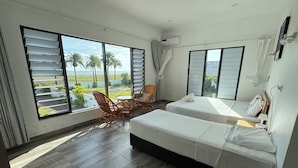 A hotel room with two beds, a dining table with chairs, large windows with blinds, and an air conditioning unit. - Lake Side Deluxe Villa (Nadi)