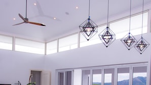 A modern kitchen with a central island, bar stools, and a dining area with chairs. - Lake Side Deluxe Villa (Nadi)