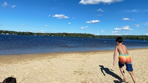 Een strand met heldere lucht en rustig water.