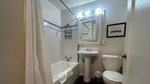 A bathroom with a bathtub, sink, and toilet. - Vintage Studio in Belltown-Space Needle (Seattle)