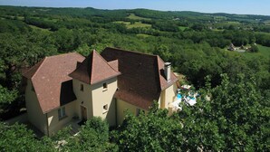 A two-story house with a swimming pool, surrounded by lush greenery and hills. - Beautifully Finished House, Modern Interiors, Private Heated Pool & Fabulous Location near Martel! (Martel)