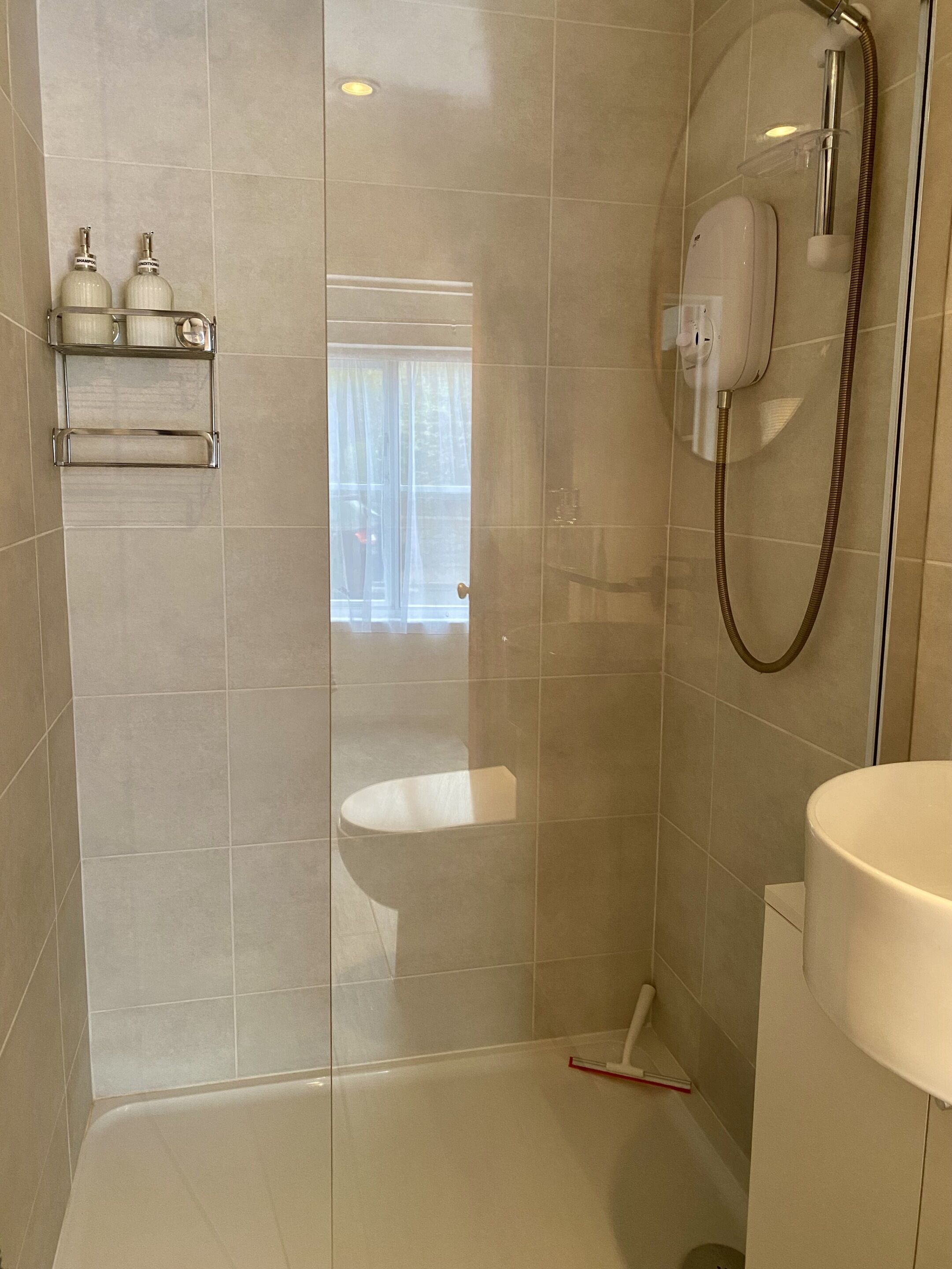 Ein Badezimmer mit Dusche, Toilette und Waschbecken.