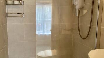 Ein Badezimmer mit Dusche, Toilette und Waschbecken.
