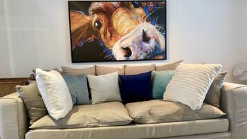 A beige sofa with multiple cushions in a living room.