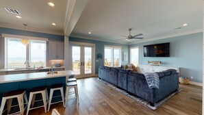 A spacious kitchen with a large island, bar stools, and a view to the outside. - Beachfront in Crystal Beach!  Beautiful views!  Game room! (Crystal Beach)