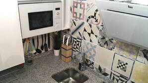 A kitchen with a microwave, sink, and patterned backsplash. - FLATS 20 Ático · Check-in 24h NEW!! Increíble ático en el CENTRO 1000 Estrellas! (Zaragoza)
