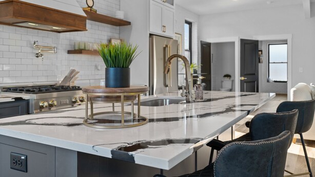 A modern kitchen with a large island, stainless steel appliances, and a marble countertop. - Luxury Downtown Loft -Walk to Dining-Near Campbell & Ft. Bragg (Lillington)