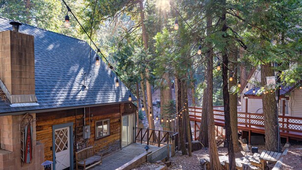 Une cabane rustique avec une façade en bois, une véranda dotée de bancs et une terrasse.