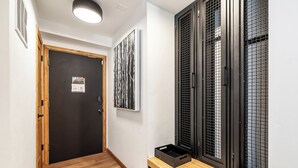 A hallway with a wooden floor, a black door, and a wall-mounted artwork. - Motherlode A5 (Breckenridge)