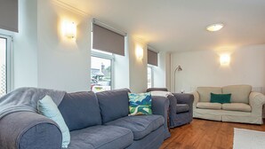 A living room with a grey sofa, a beige sofa, and a patterned rug. - 5 bedroom accommodation in Stoke Gabriel, near Totnes (Stoke Gabriel, near Totnes)