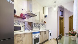 Une cuisine moderne équipée d’un four à micro-ondes, d’un four traditionnel et d’un lave-linge.