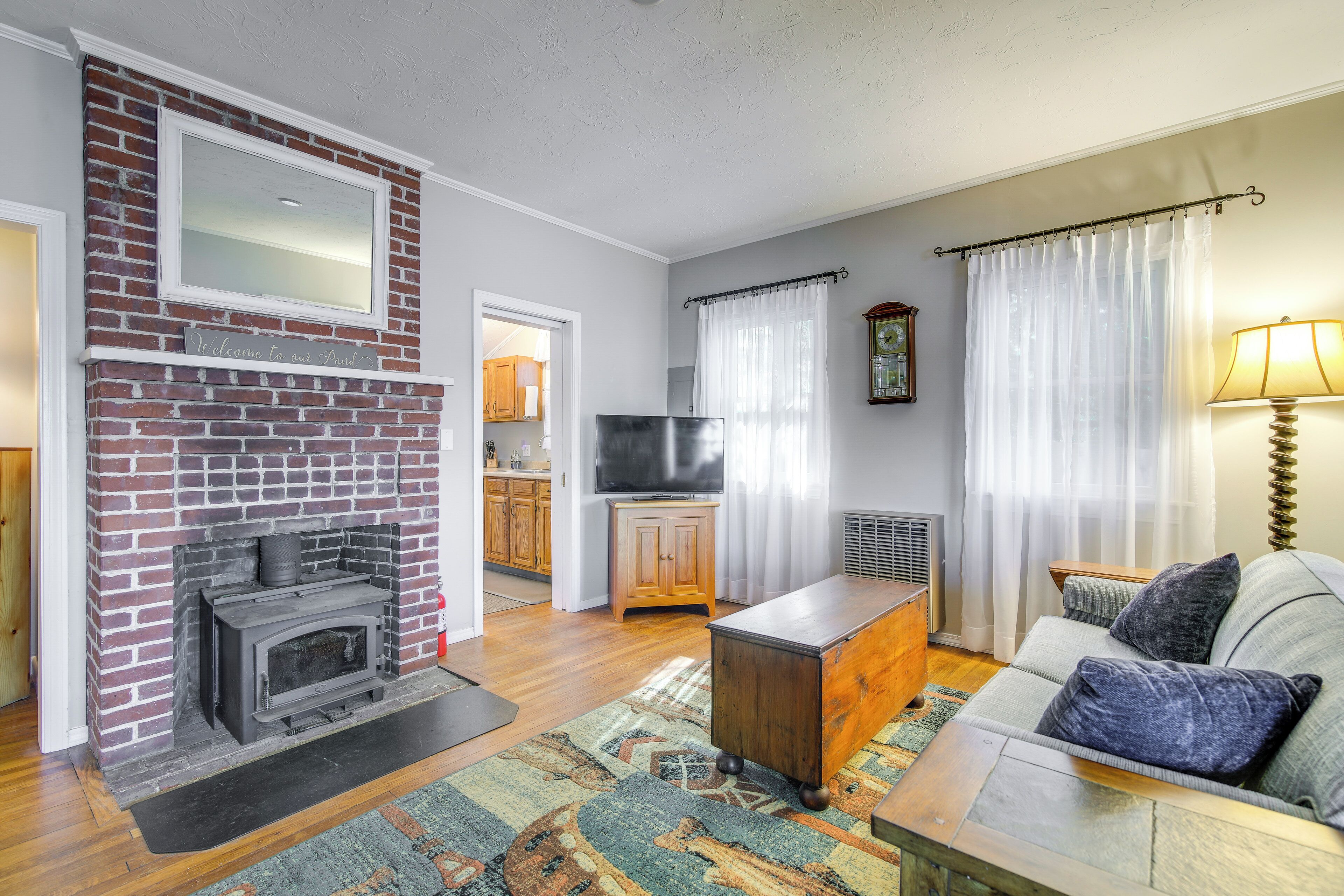 A living room with a brick fireplace, a sofa, a coffee table, and a television.