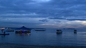 A waterfront area with boats and a covered structure.