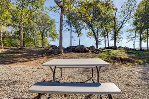 A picnic table in a natural setting with trees and rocks. - Quiet Caledonia Cabin: 18 Mi to Council Bluff Lake (Caledonia)