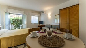 A hotel room with a bed, a dining table with cups and a teapot, a sofa, and a TV. - Residence in Giannella with 0 bedrooms sleeps 4 (Giannella)