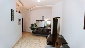 A hallway with a sofa, a dining table, and a potted plant. -  Studio. 5 Lesi Urainky blvd. Near Parus, Gulliver  (Passau)