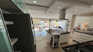 Et moderne køkken med en central ø, indbyggede apparater og et spiseområde med udsigt.