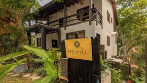 A wooden gate with a sign reading "PEARL" and a beaded decoration hanging on it.