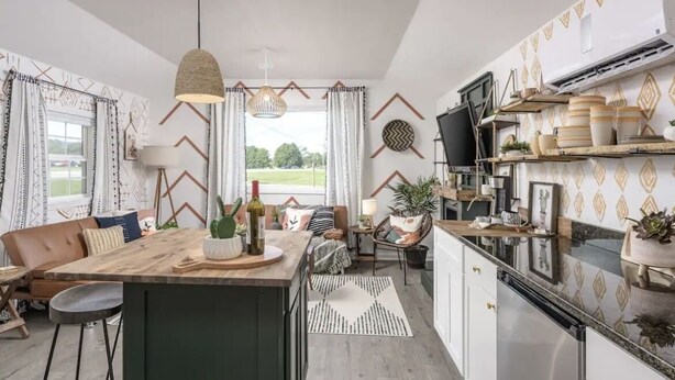 A modern kitchen with a central island, built-in appliances, and a dining area with a sofa and chairs. - Perfect cozy bungalow for a weekend away or a week fishing🐟 (Sale Creek)