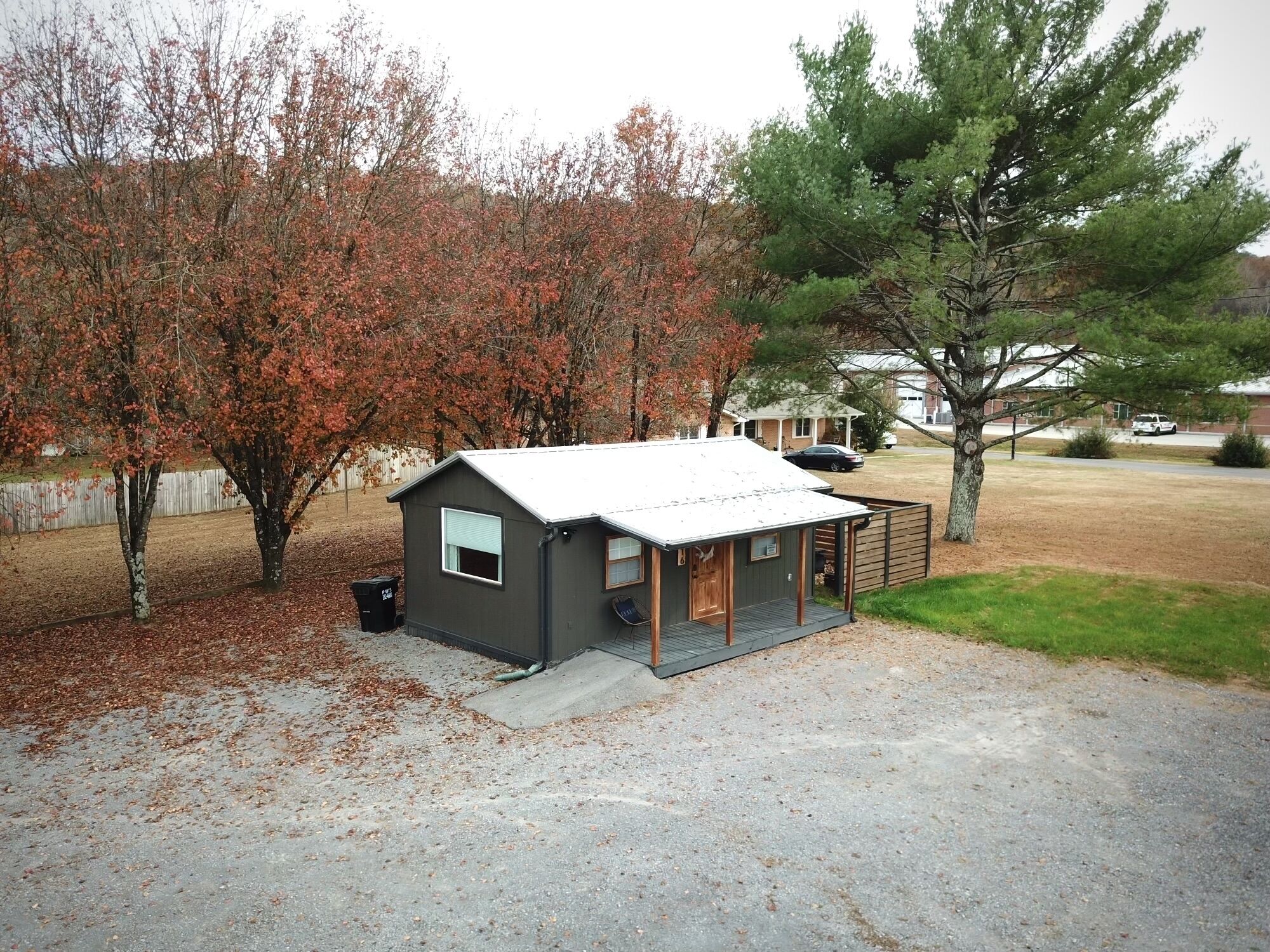 Une petite cabane à un seul étage, avec un toit en métal et une véranda.