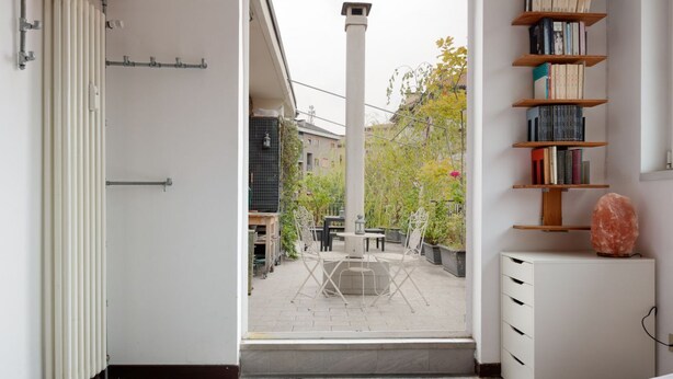 A room with a view of an outdoor patio, a radiator, a bookshelf, and a cabinet. - GuestHost - APT with large terrace - Calvairate neighborhood (Milano)