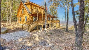 A wooden cabin with a balcony, surrounded by trees and a clear view of the landscape. - Family Retreat in this Gorgeous Log Cabin overlooking the Arkansas Grand Canyon! (Jasper)