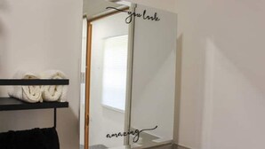 Ein Badezimmer mit Spiegel, Handtuchhalter und Ablagefläche mit Handtüchern.