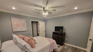 A bedroom with a bed, a dresser, a ceiling fan, and a television. - 2bed/2bath Cottage in Downtown Houma. 30+ day stays welcome. (Houma)