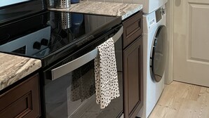 Une cuisine équipée d’un four à micro-ondes, d’un four traditionnel et d’un lave-linge.