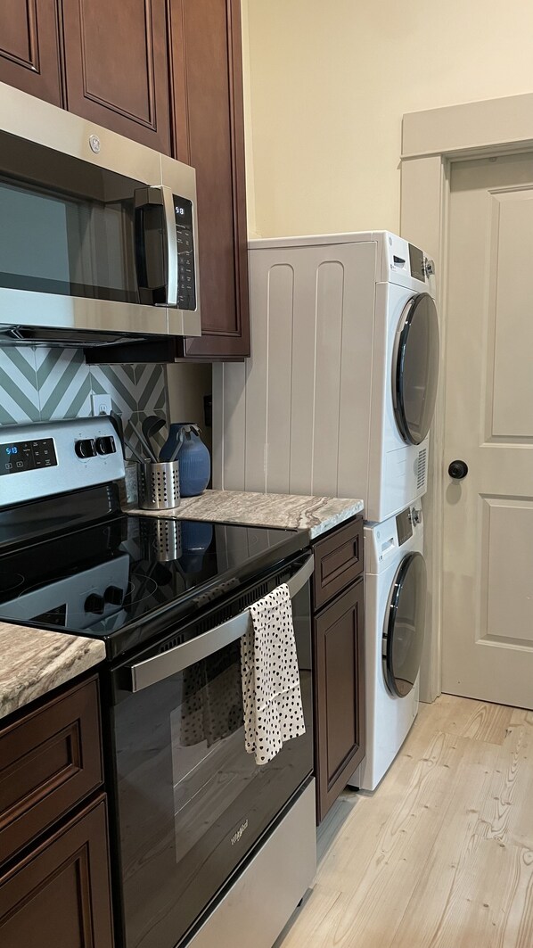 Una cocina equipada con microondas, horno y lavadora.