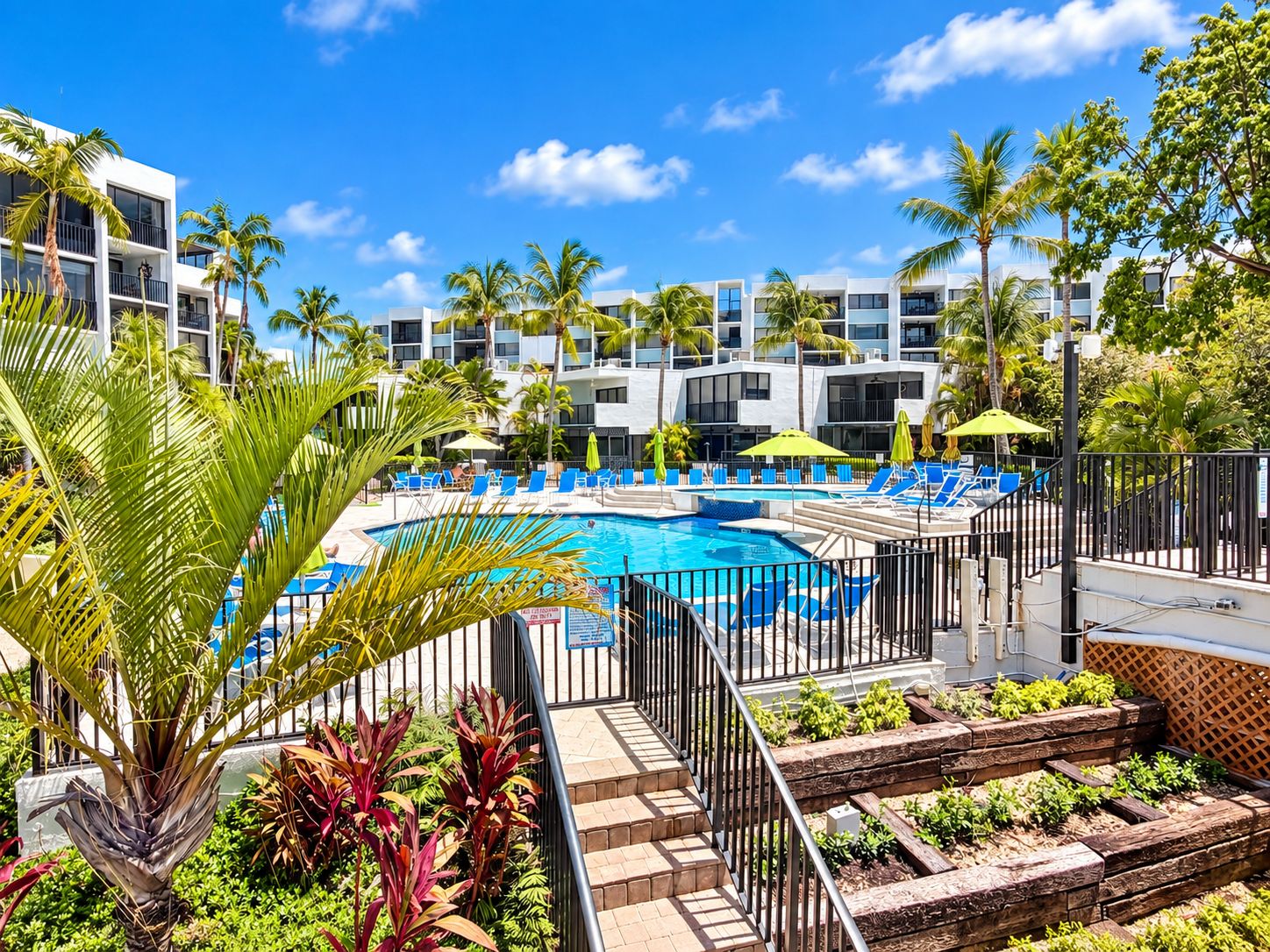 Un resort con piscina, lettini e palme.