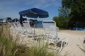 Strandstühle und Sonnenschirme an einer Uferlage.