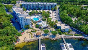 An aerial view of a hotel with multiple buildings, a swimming pool, and a dock with boats. - Sunsets and Turtles – Key Largo Moon Bay Condo – Boat Slip/Lift Optional (Key Largo)