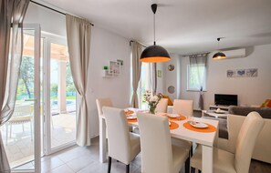 Enjoy meals in this stylish dining area with a table for four, sliding glass door, and mounted TV.