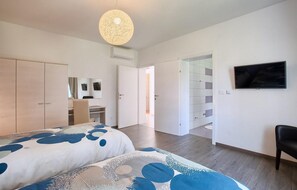 Relax in a spacious room with a large bed, desk, and TV, plus a separate bathroom and closet.